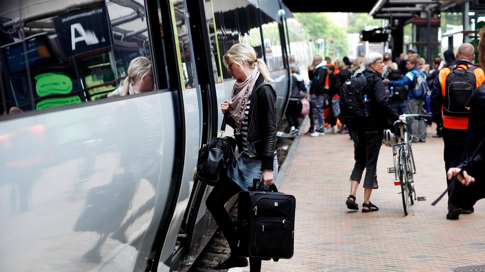 Togstation med tog og passagerer